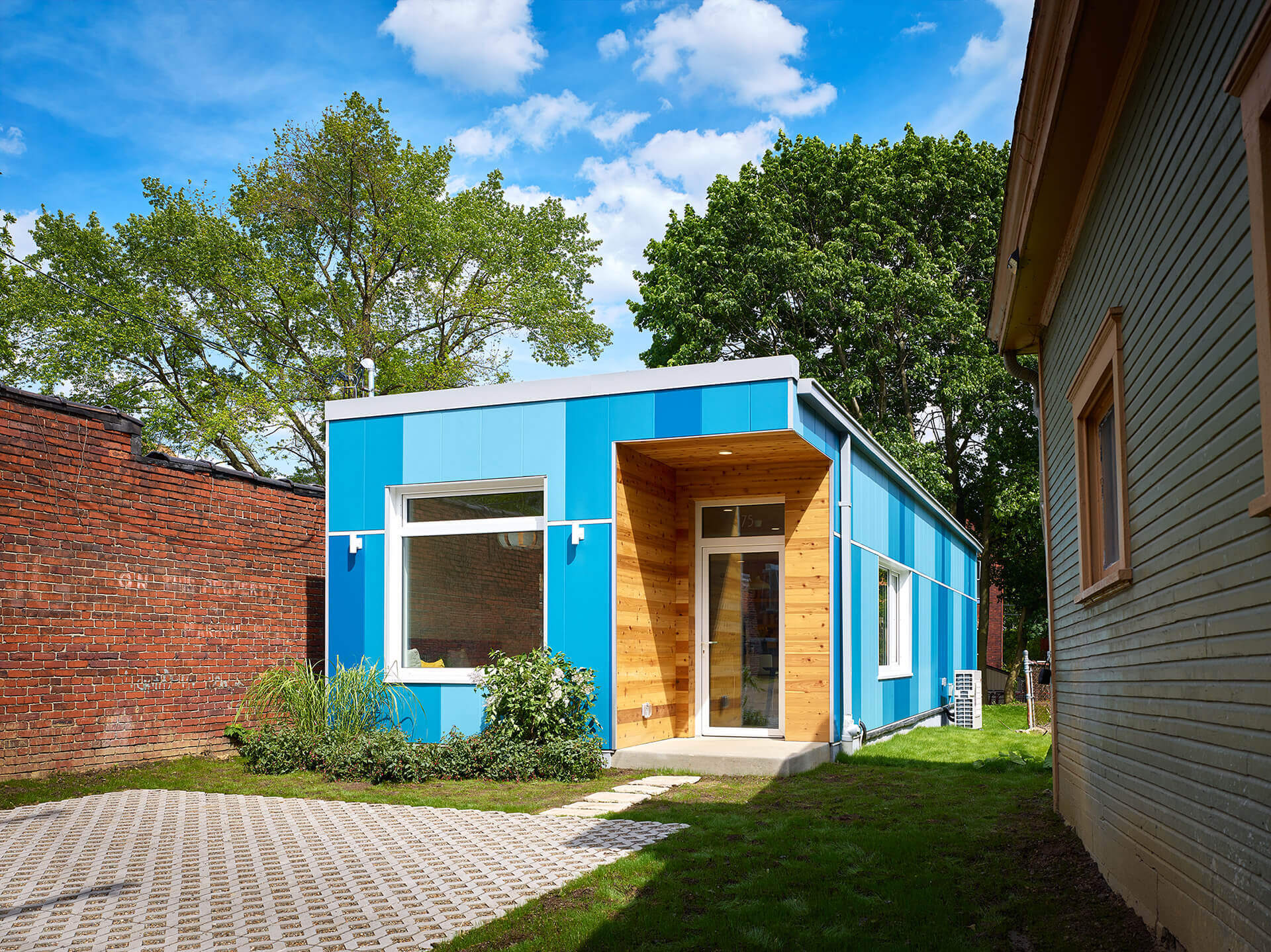 Small modular home with vertical blue custom color Illumination panels in a variety of shades