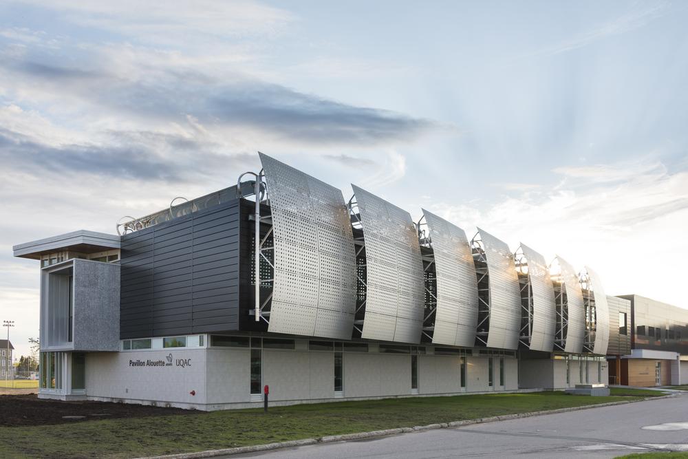 A convention center with concrete aesthetic cladding from Nichiha&rsquo;s fiber cement cladding product line. Large, steel, rounded panels stick out from the sides.