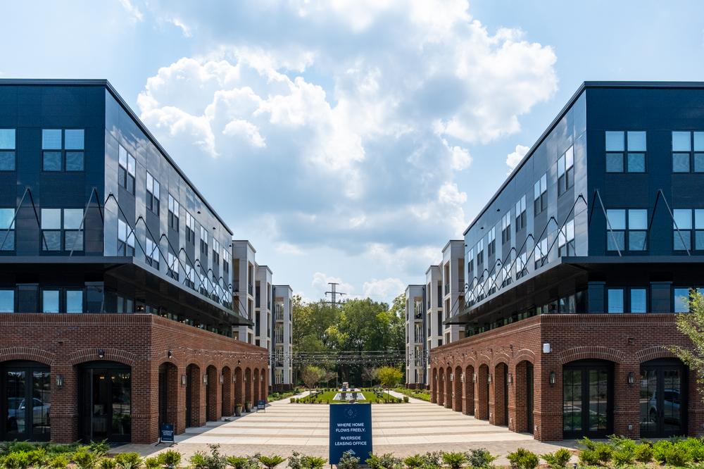 A multifamily apartment complex utilizing brick textures and sleek design with Nichiha&rsquo;s fiber cement cladding. The complex is split by an open plaza.