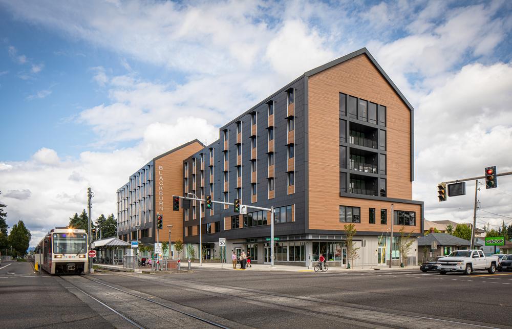 Condo building utilizing Nichiha&rsquo;s VintageWood fiber cement cladding. The condo sits behind a 4-way intersection where cars wait at stoplights.
