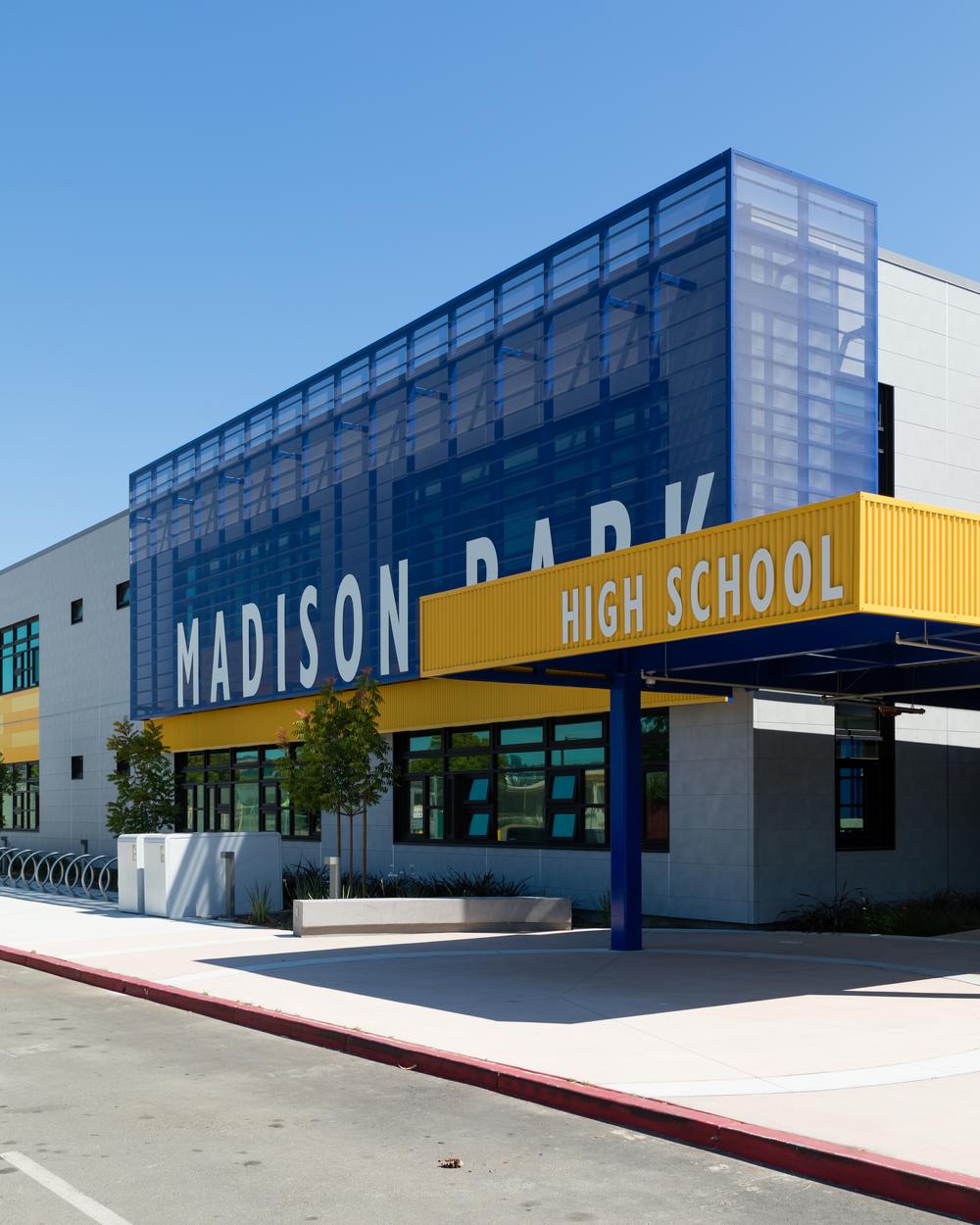 A shot of Madison Park High School using Nichiha&rsquo;s fiber cement cladding in gray from the concrete series with the colors yellow and blue as accents.