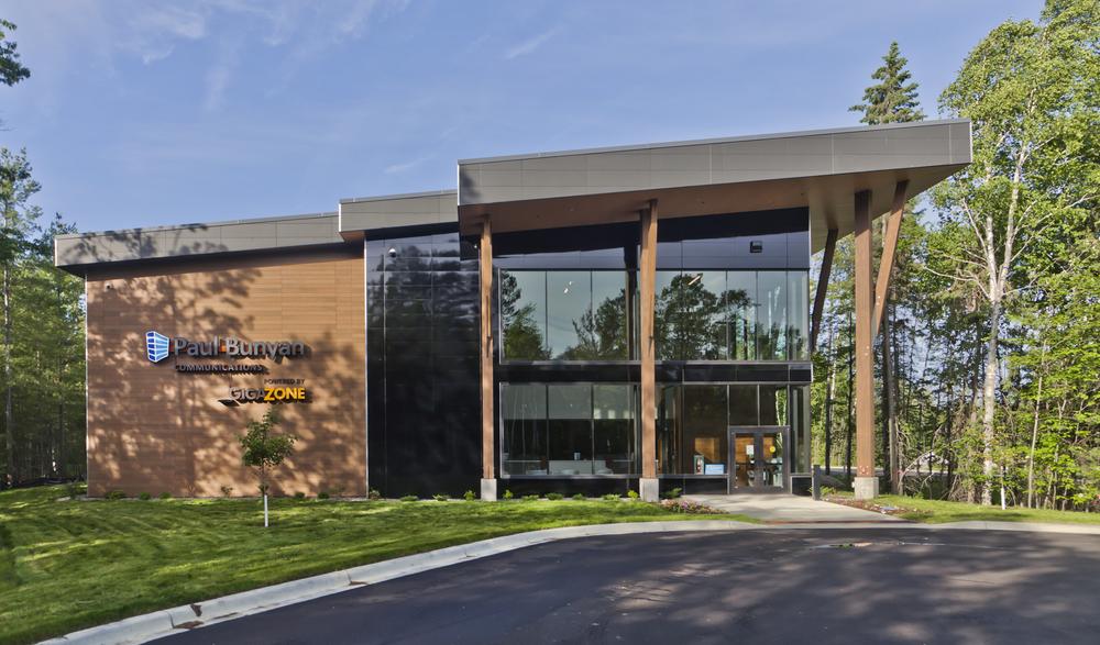 An image of the Paul Bunyan Communications building from the front, showcasing black Miraia and VintageWood fiber cement siding next to large vertical windows.