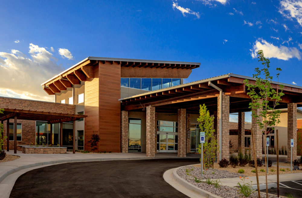 An image of the drive-up front of a medical building with VintageWood lap siding and stone pillars supporting a drive-thru canopy.