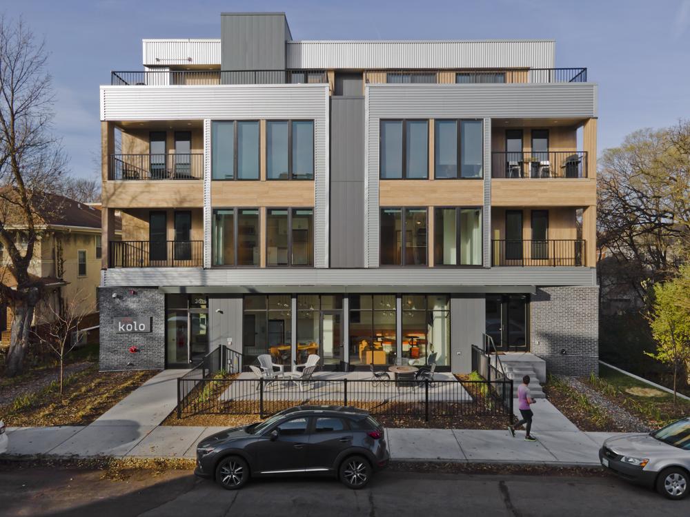 Exterior view of a modern commercial building with a mix of brick and wood siding showcasing multiple large windows.