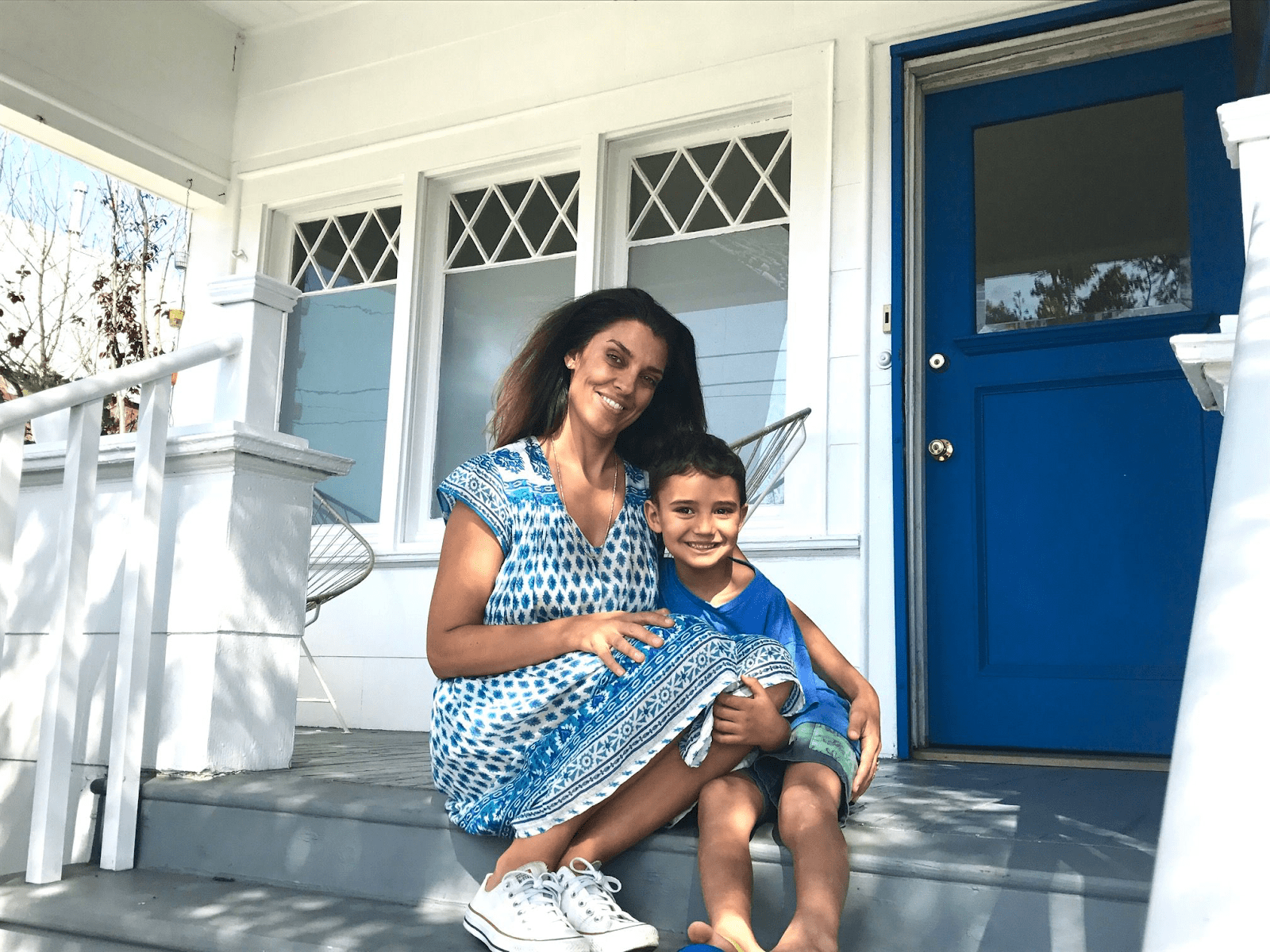 Rosa and her son on their front porch before the renovation