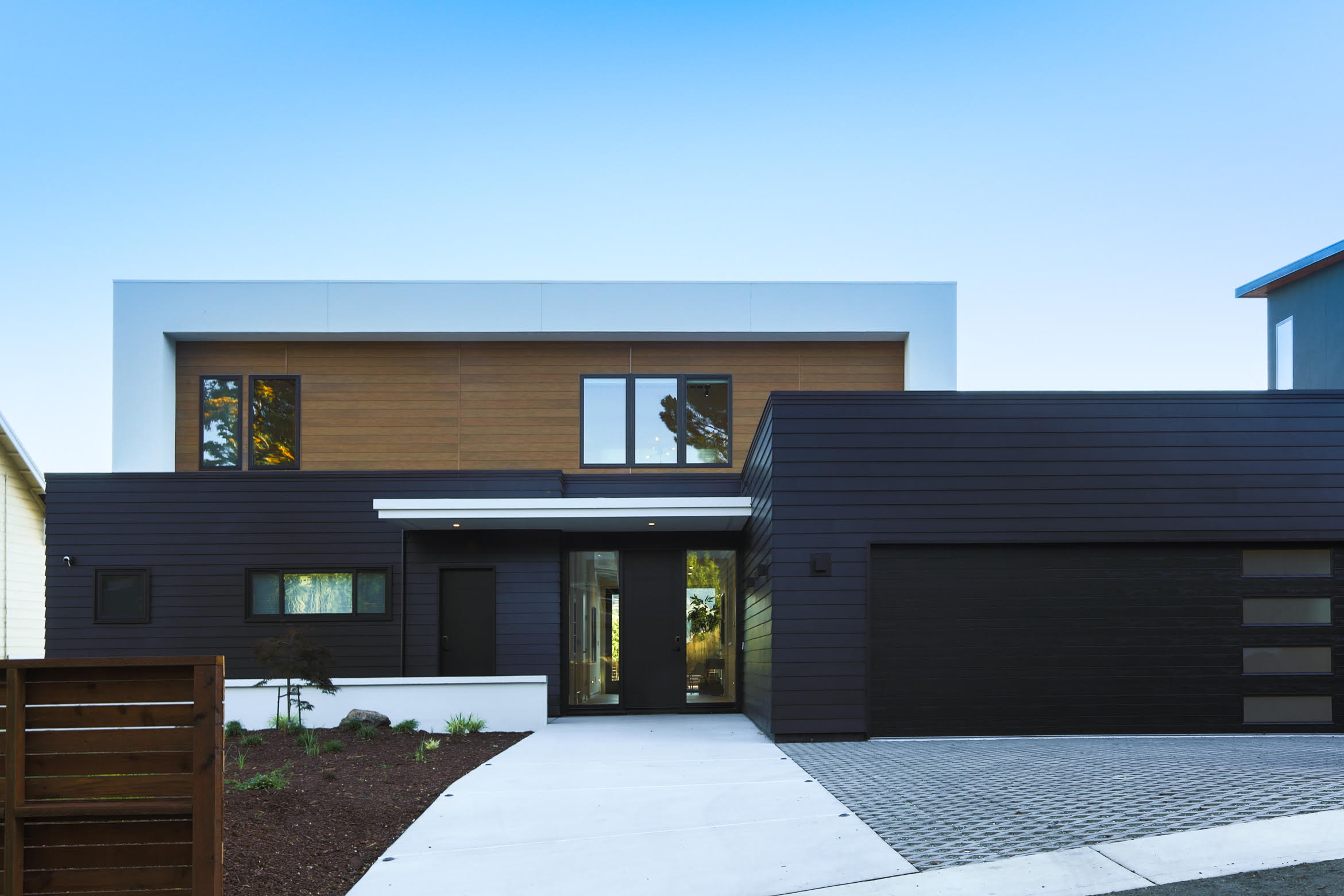 Home with brown and black exterior with attached garage.