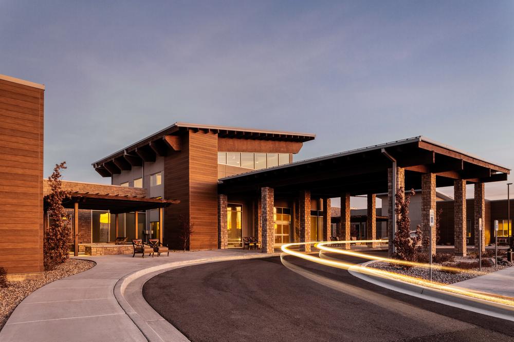 Utah building at sunset that has paved driveway and small outdoor seating area