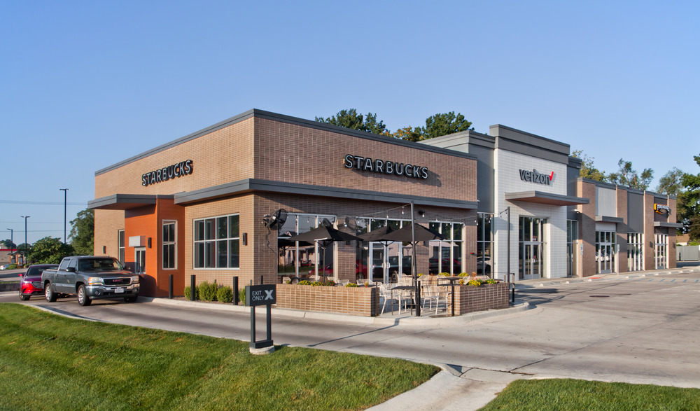 The corner of the Brentwood Plaza strip mall housing Starbucks, Verizon and Firehouse Subs utilizing Nichiha&rsquo;s fiber cement cladding. There is a truck in the Starbucks drive through.