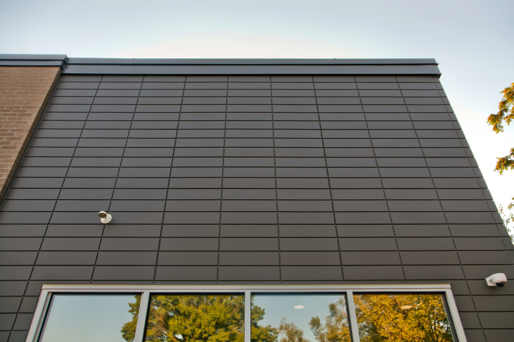 A close-up of Nichiha&rsquo;s fiber cement cladding on a Firehouse Subs exterior wall. There are snippets of a clean window at the bottom.