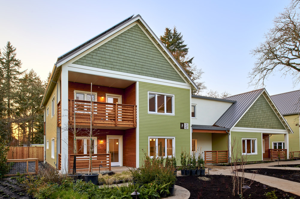 These apartments have green horizontal siding. There are various touches of wood accents throughout the apartment&rsquo;s exterior.