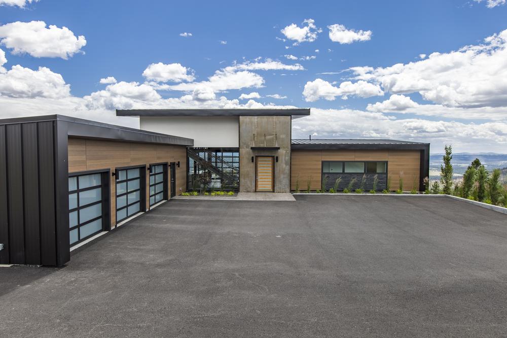 An industrial-style home with Nichiha&rsquo;s fiber cement siding with blue skies and clouds in the background.
