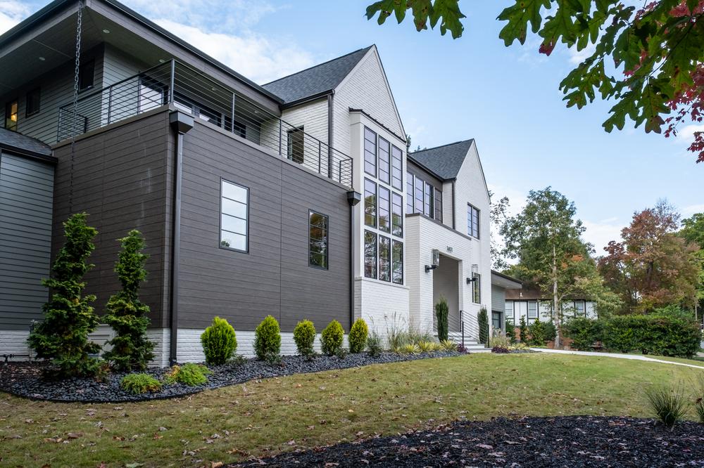 A dark brown and white home with large windows decorated with Nichiha&rsquo;s fiber cement siding.