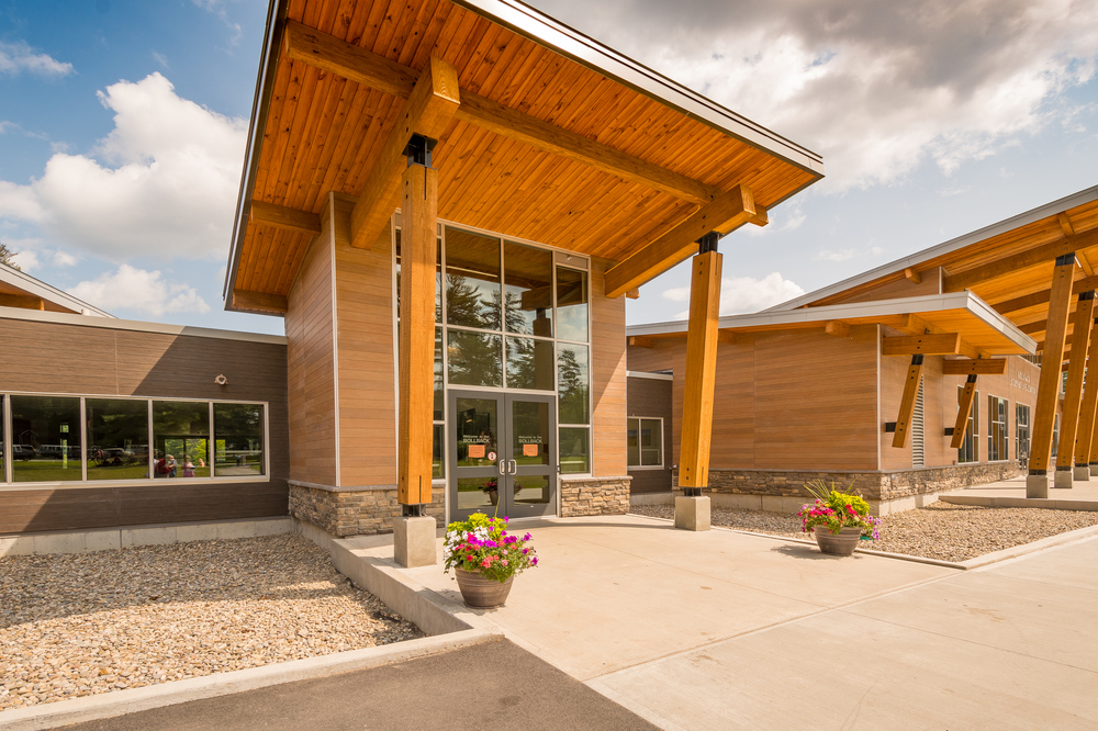 Entrance to a school building with wood columns and canopies.