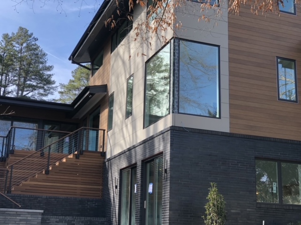 Modern home with brick lower floor and fiber cement siding upper floors.