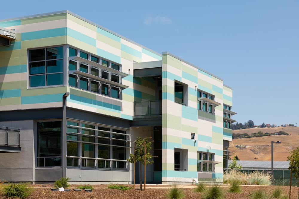 Tennyson High School, clad in Nichiha’s fiber cement panels in light green and blue.
