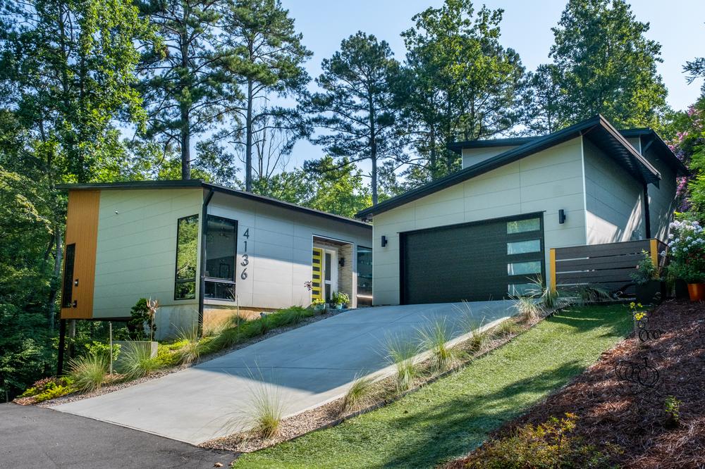 This modern home has a steep driveway that leads to a one-car garage.