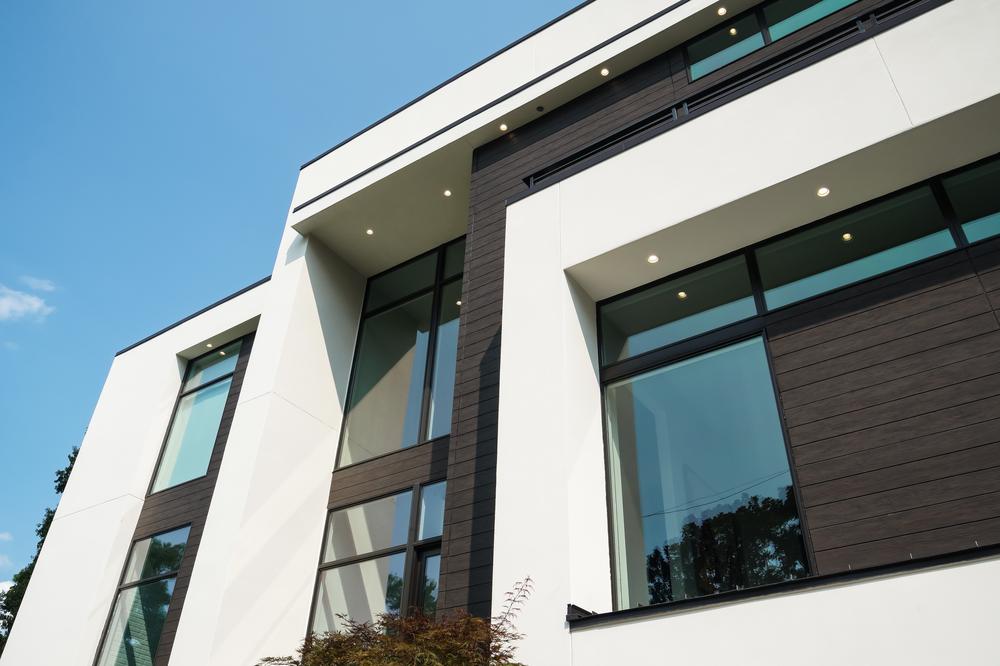 A home in Atlanta Georgia that&rsquo;s white and dark brown with large windows utilizing Nichiha&rsquo;s VintageWood. This image looks up at the home&rsquo;s siding.