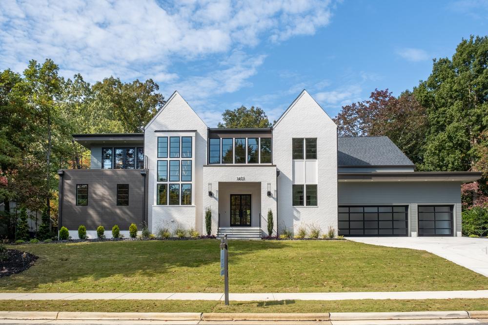 A white and light brown home has a three-car garage and is decorated with Nichiha’s fiber cement siding.