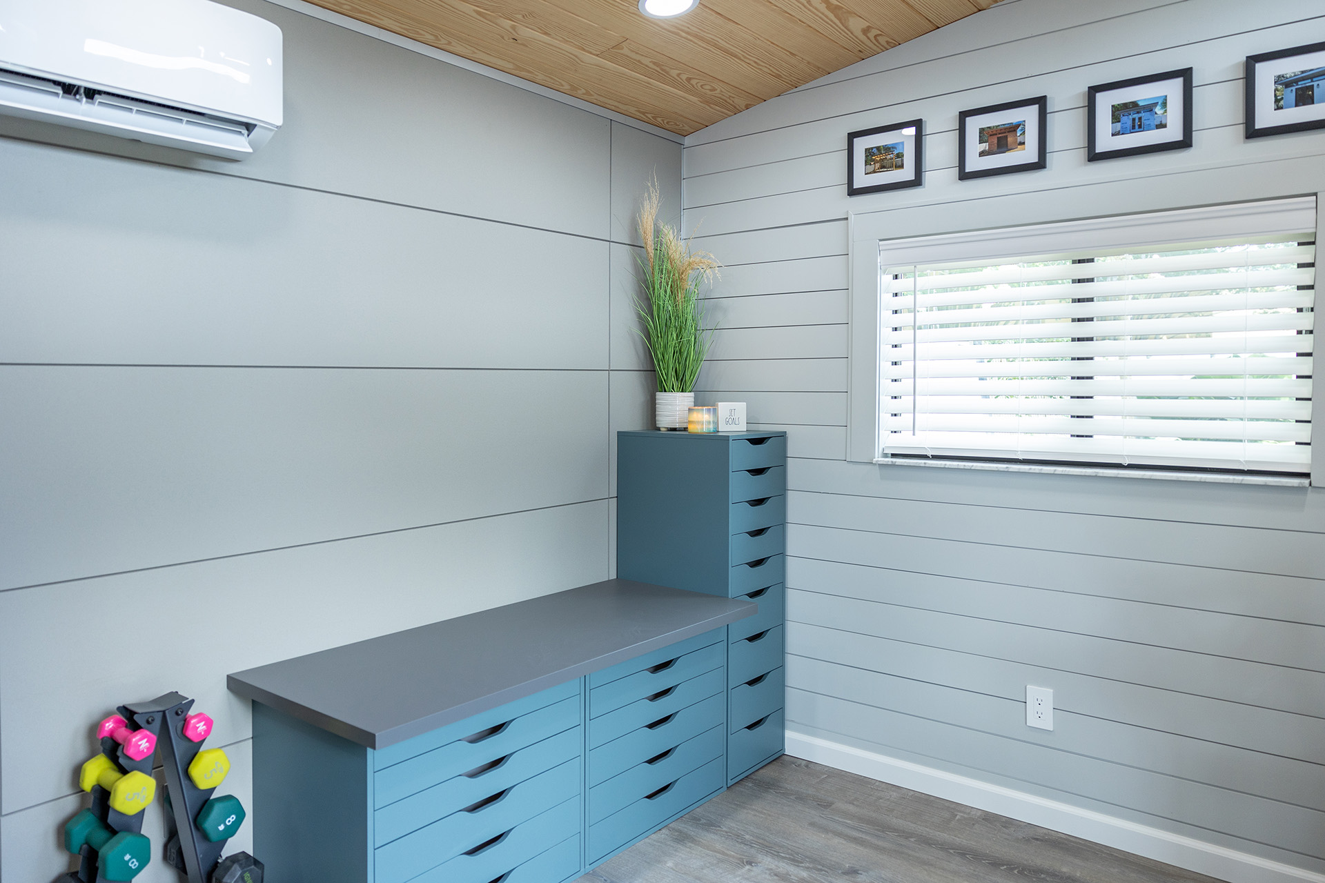 Inside of home studio that has desk space and workout equipment in front of ArchitecturalBlock panels in Gray