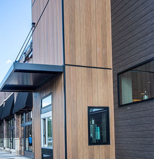 Exterior view of modern residential building with fiber cement panels and large windows